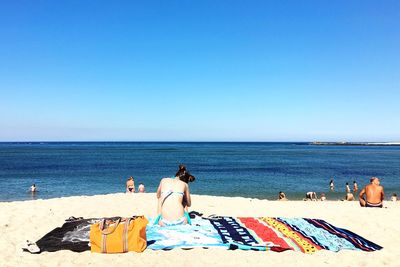 Rear view of man sitting on beach