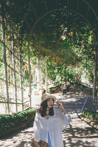 Portrait of woman standing against trees