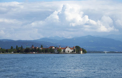 Scenic view of lake by buildings against sky