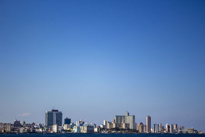 Buildings in city against blue sky