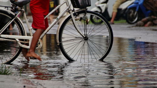 Low section of bicycle on wet street during rainy season