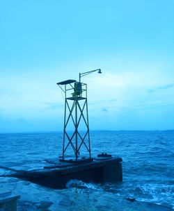 Lifeguard hut on sea against blue sky