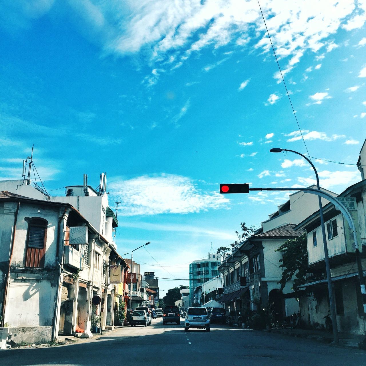 building exterior, transportation, architecture, car, built structure, street, land vehicle, sky, road, mode of transport, the way forward, city, residential building, house, diminishing perspective, residential structure, cloud, blue, cloud - sky, street light