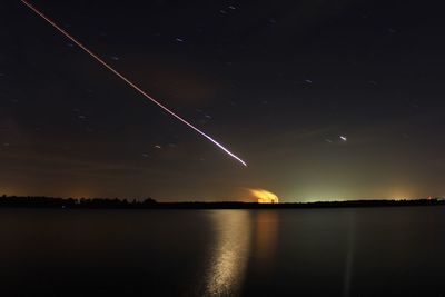 Scenic view of lake against sky at night