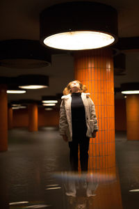 Digital composite image of woman jumping in illuminated garage