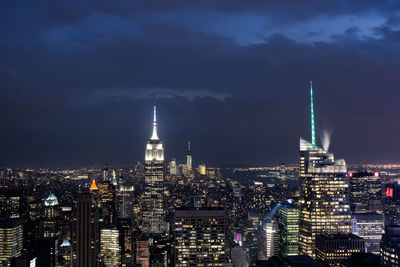 Illuminated cityscape against sky at night