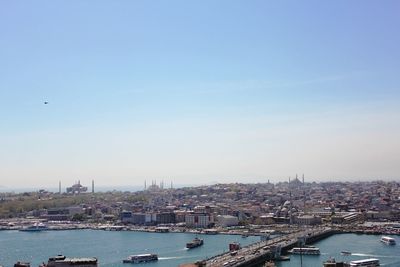 Boats in river with city in background