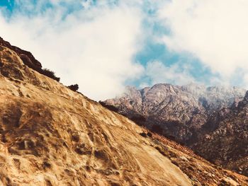 Low angle view of mountains against cloudy sky