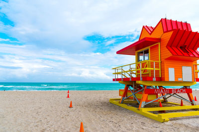 Lifeguard hut on beach against sky