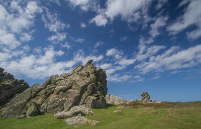 Rock formations on field against sky