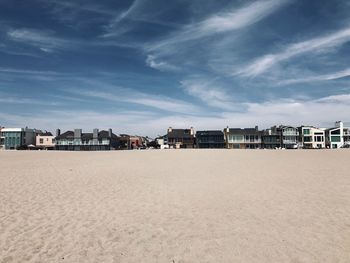 Beach by buildings against blue sky