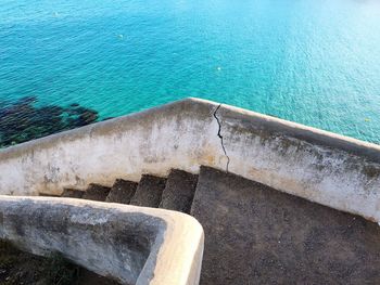 High angle view of stone wall by sea