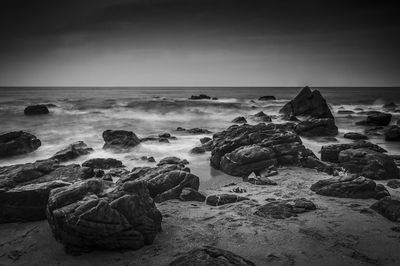 Rock on shore against sky