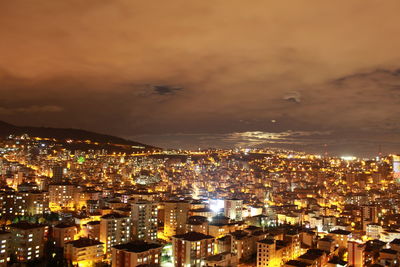Illuminated cityscape against sky at night