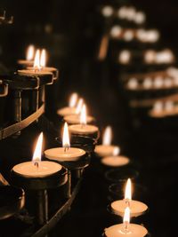Close-up of candles burning in church at night