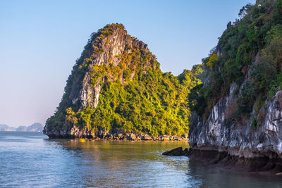 Scenic view of rock formation in sea against clear sky
