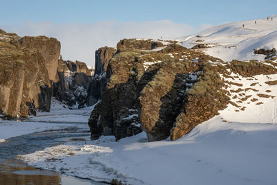 Snow covered land and mountains against sky