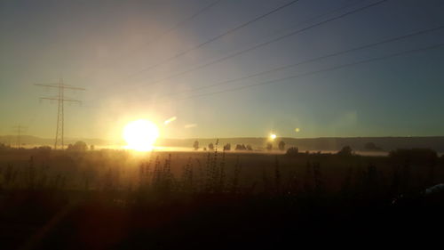 Silhouette of electricity pylon at sunset