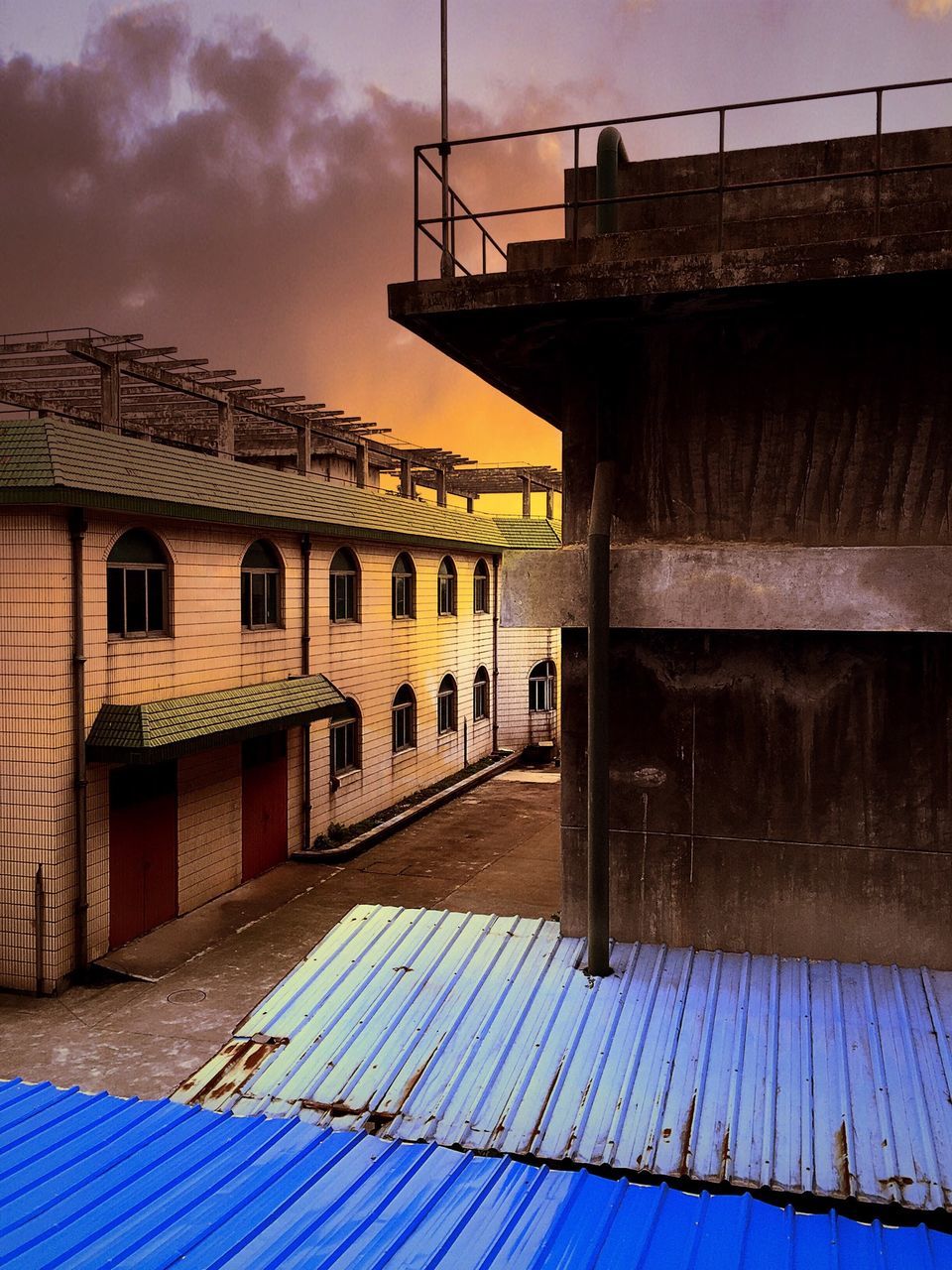 architecture, built structure, building exterior, sky, house, low angle view, railing, building, the way forward, residential structure, day, outdoors, no people, sunlight, cloud - sky, residential building, cloud, brick wall, connection, exterior