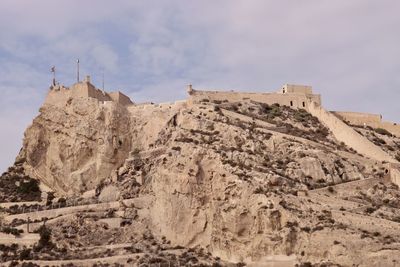 Low angle view of castle on mountain against sky