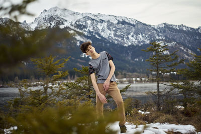 Full length of young woman standing on snow covered mountain