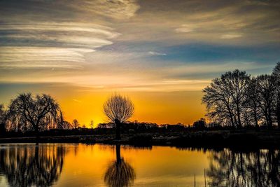 Reflection of trees in lake during sunset