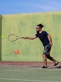 Full length of man playing tennis