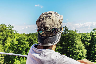 Rear view of person wearing cap looking at forest