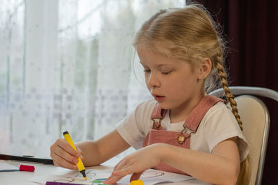 Girl drawing over paper on table