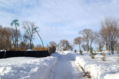 Scenic view of snow covered field against sky