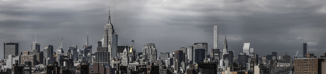 View of cityscape against cloudy sky