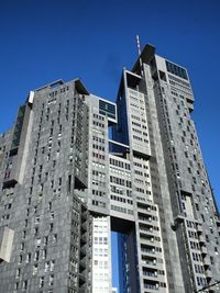 Low angle view of modern buildings against clear blue sky