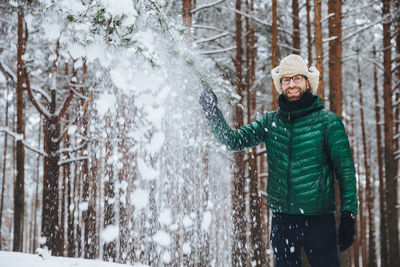 Young woman in snow covered trees