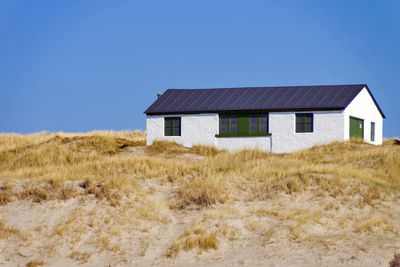 Abandoned house on field against clear sky