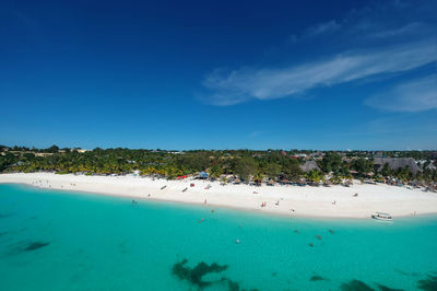 Scenic arial view of sea and beach against blue sky