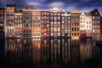 Reflection of buildings in calm river in city