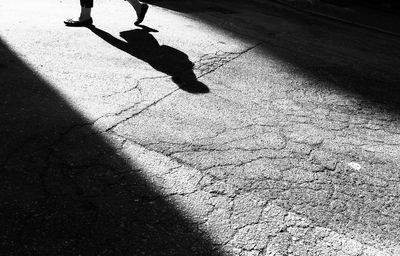 Low section of person walking on street in city