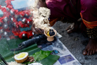 Low section of man with religious offerings