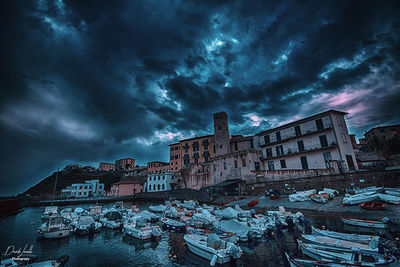 Buildings against cloudy sky at dusk