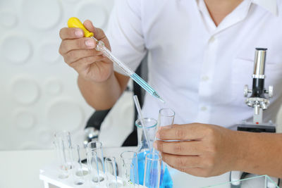 Midsection of scientist performing experiment