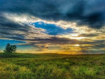 Scenic view of field against dramatic sky