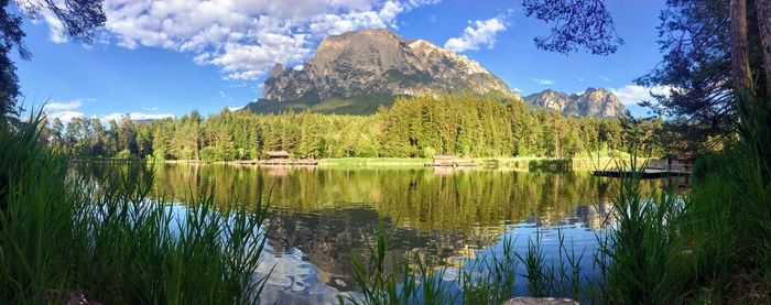 Scenic view of lake by trees against sky