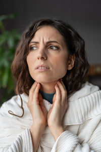 Lymph node inflammation. sick unhealthy woman at home touching inflamed swollen glands