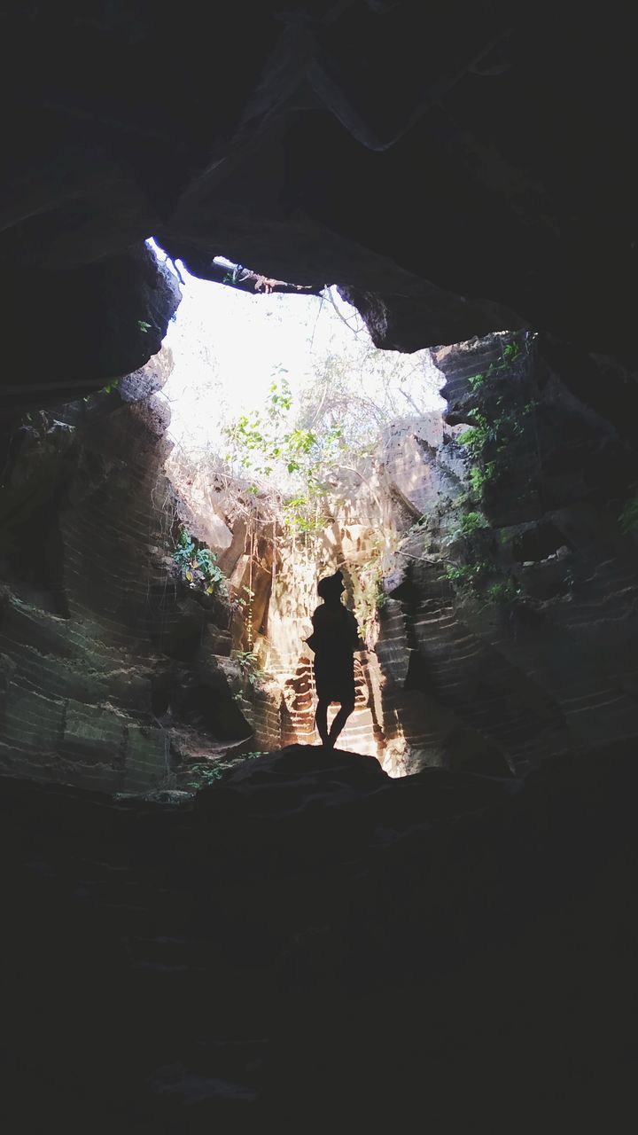 cave, darkness, one person, nature, lifestyles, leisure activity, rock, light, outdoors, day, standing, men, adult, sunlight, water, rock formation, full length, reflection, beauty in nature, women, land