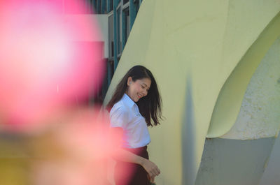 Smiling woman walking against steps