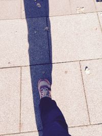 Low section of woman standing on tiled floor