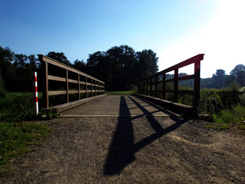 Road by trees against clear sky