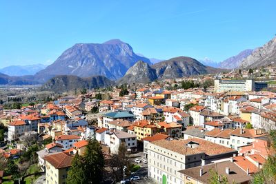 High angle view of townscape and mountains against blue sky