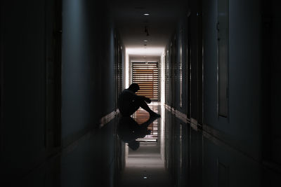 Rear view of woman standing in corridor of building