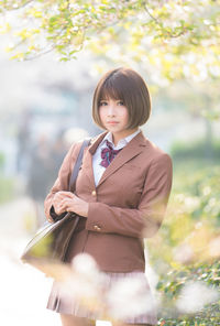 Portrait of woman with bag standing outdoors